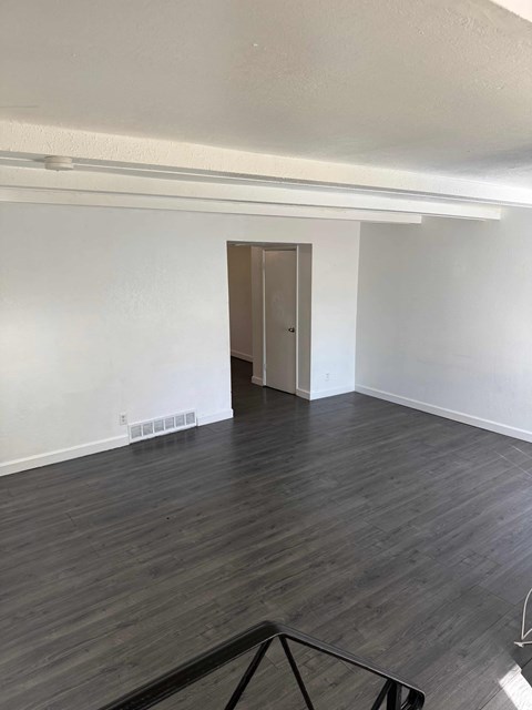 A room with a wooden floor and a door.