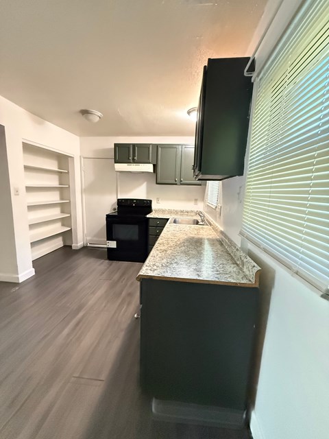 A kitchen with a black fridge and a black microwave.