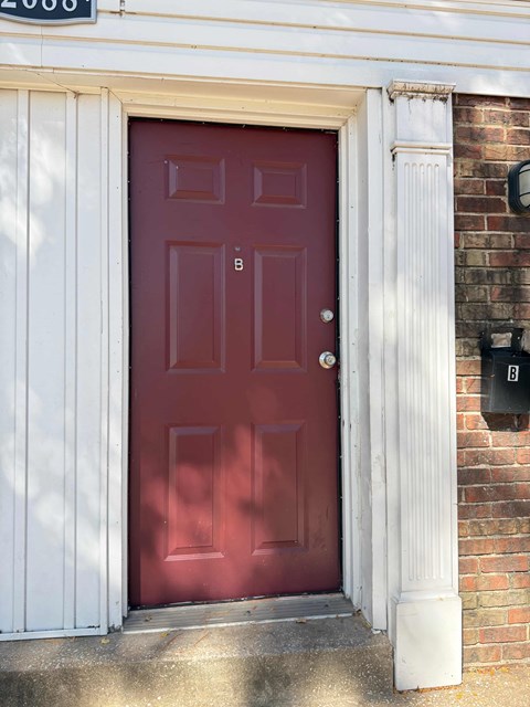 A red door with a mailbox on the right side.