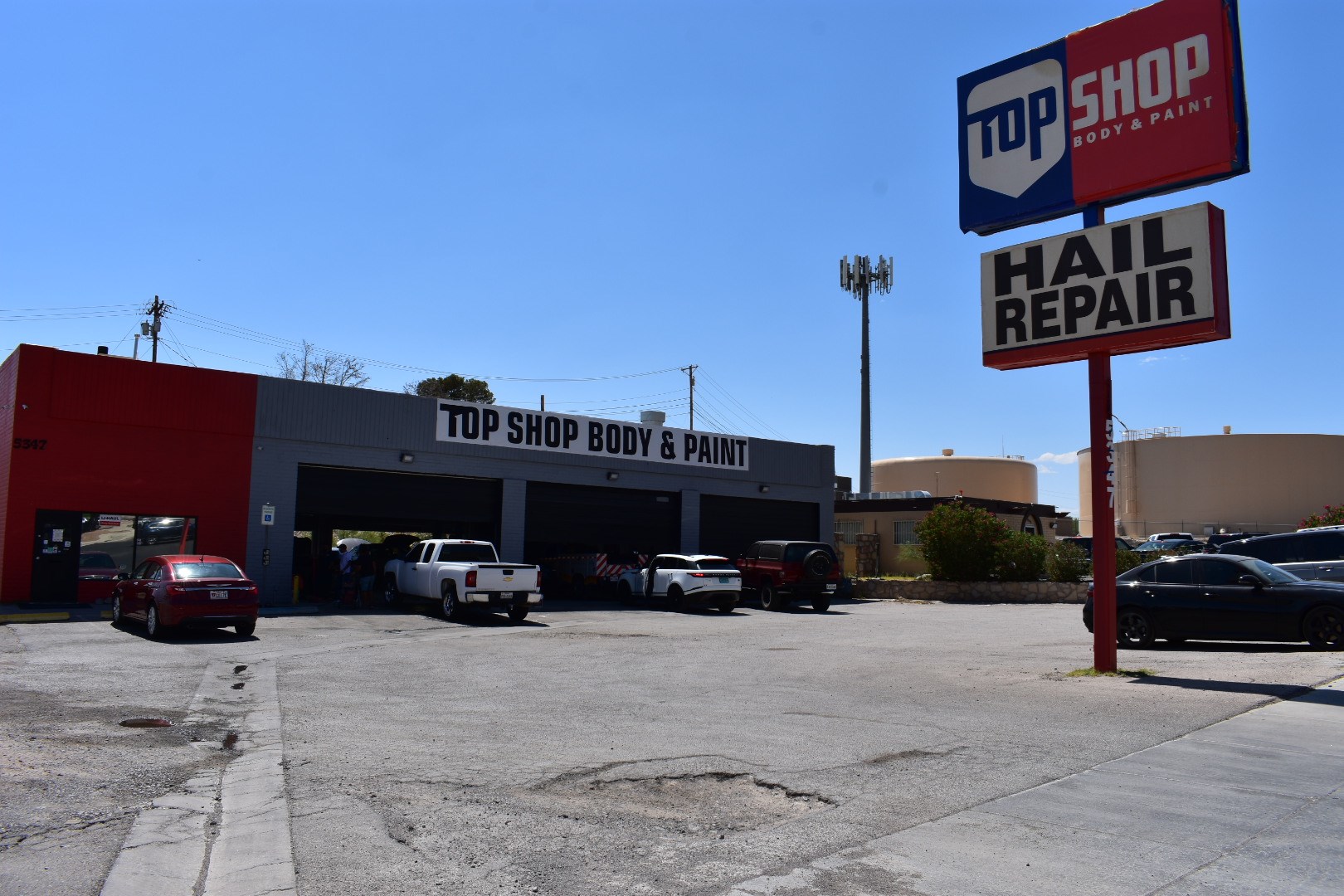 A car repair shop with a sign that says "TOP SHOP BODY & PAINT".