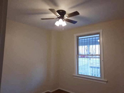 a bedroom with a ceiling fan and a window