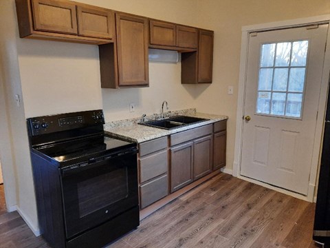 a kitchen with a stove and a sink and a door