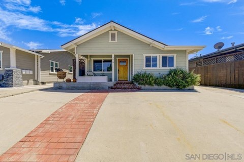A San Diego MLS listing photo of a single-story house with a yellow front door.