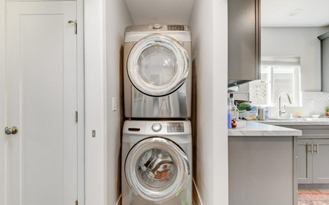 A stack of two washing machines in a small room.
