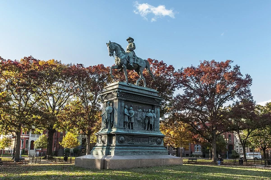 a statue of a man riding a horse in a park