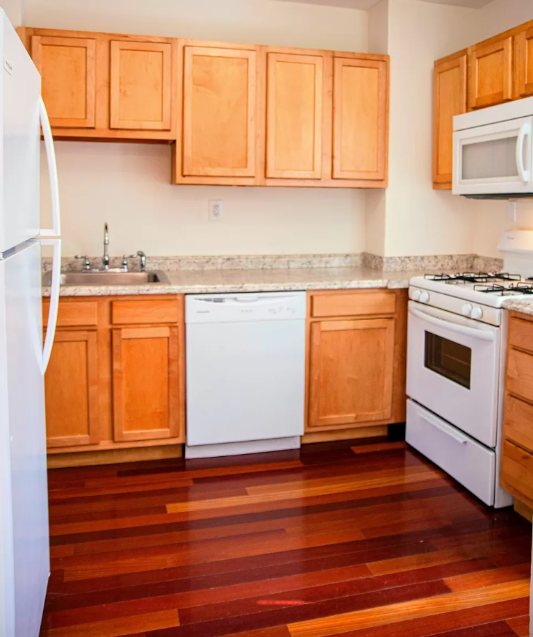 a kitchen with wooden floors and white appliances
