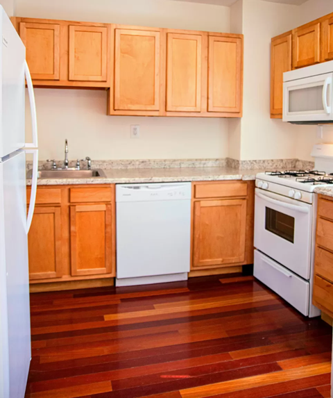 a kitchen with wooden floors and white appliances