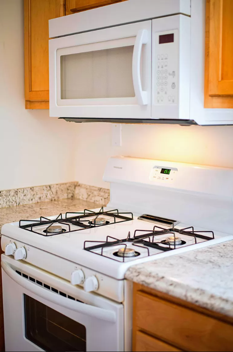 a white stove top oven sitting under a microwave