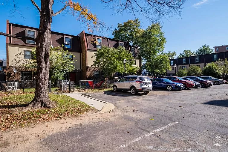 a parking lot with cars parked in front of an apartment building