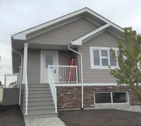 a gray house with a porch and stairs