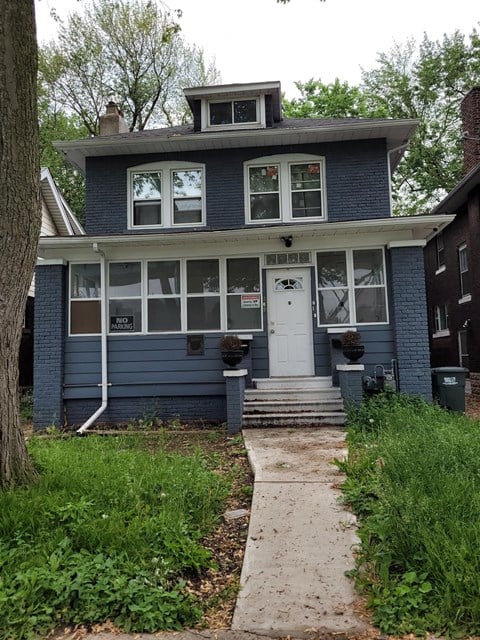 the front of a blue house with a white door