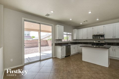 A kitchen with white cabinets and a black countertop.