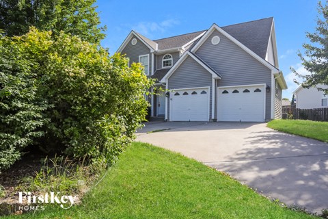 A house with a driveway and garage doors.