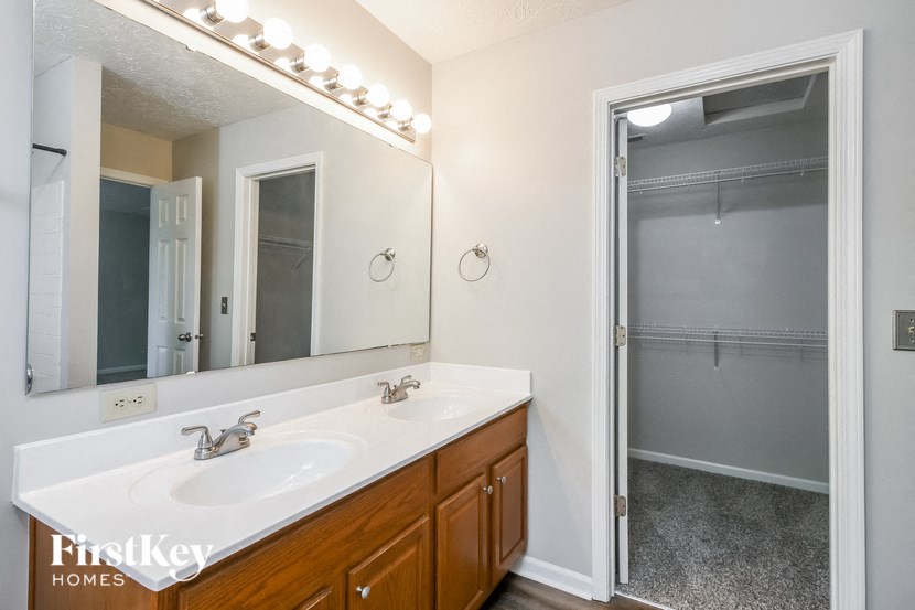 a bathroom with a sink and a shower and a mirror