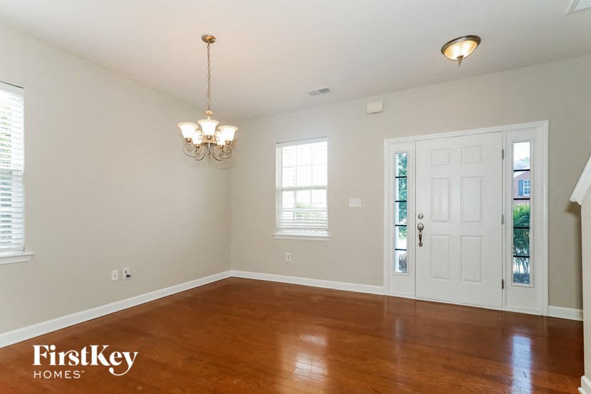 an empty living room with wood floors and a white door