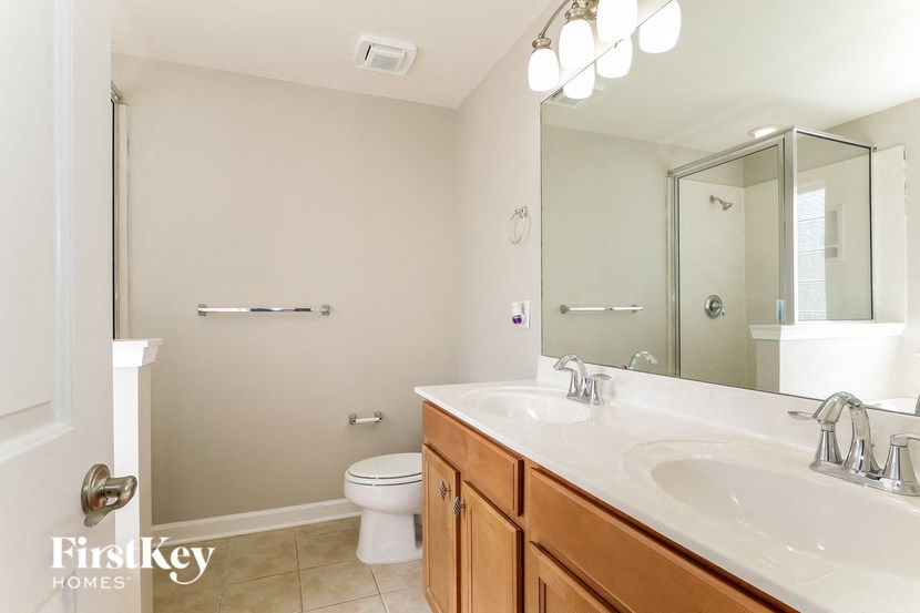 a bathroom with two sinks and a shower and a toilet