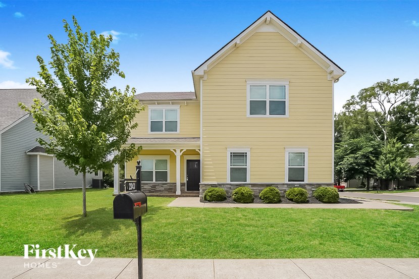 a yellow house with a mailbox in front of it