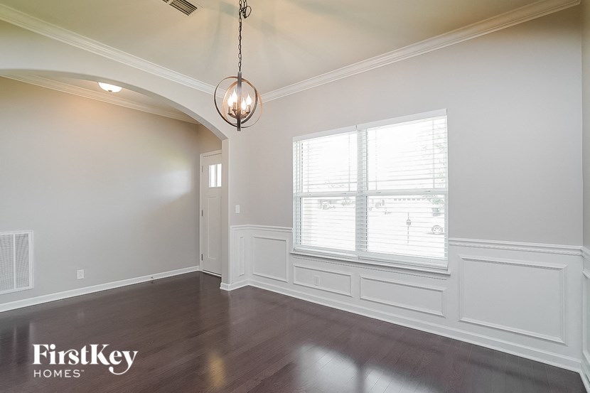 an empty living room with white walls and a large window