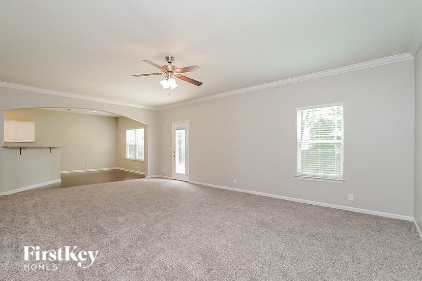 an empty living room with a ceiling fan