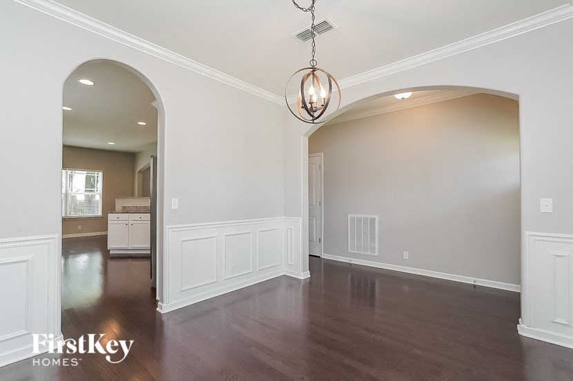 an empty living room with white walls and wood floors