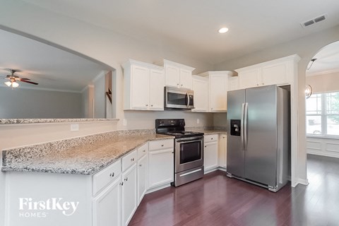 a kitchen with white cabinets and a stainless steel refrigerator