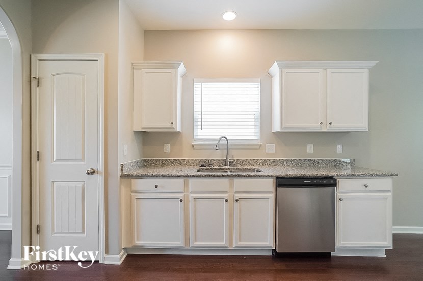 a kitchen with white cabinets and a sink and a dishwasher