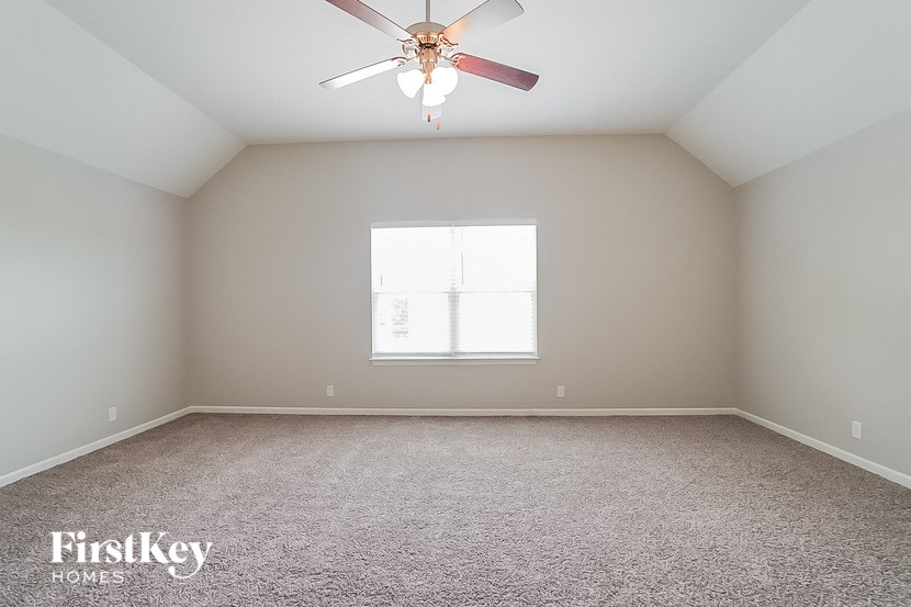 a empty room with a ceiling fan and a window