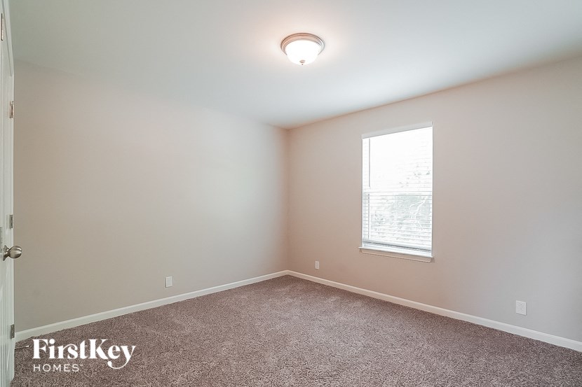 an empty room with a window and a carpet