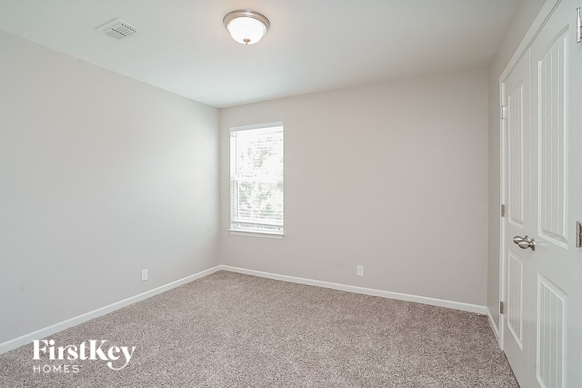 an empty room with a white door and a window