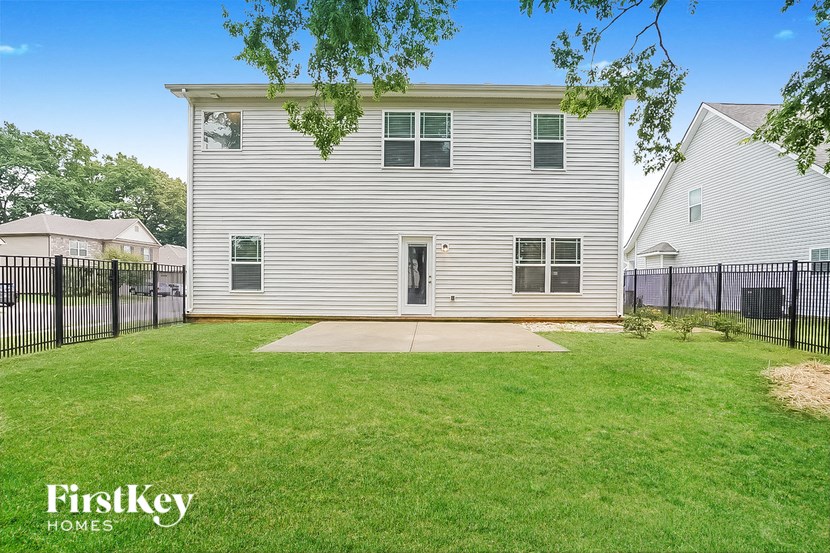 a white house with a yard and a black fence