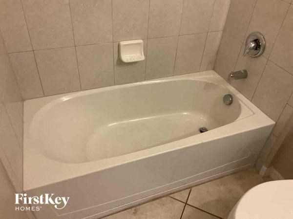 a white bath tub in a bathroom with a toilet