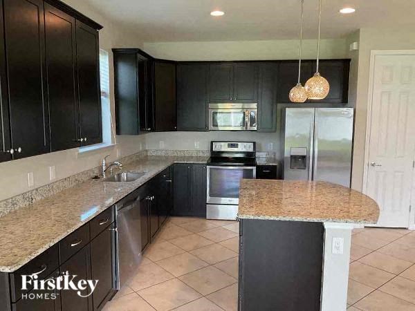 a kitchen with black cabinets and granite counter tops