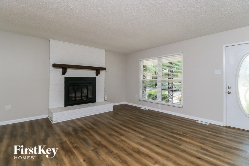 a living room with a fireplace and wooden floors