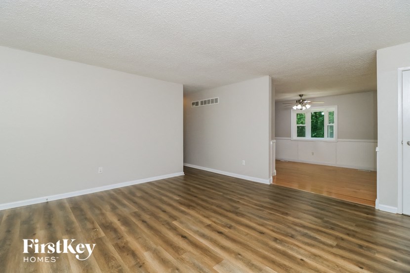 the living room and dining room of an empty house with wood floors