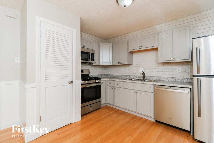 a kitchen with white cabinets and stainless steel appliances