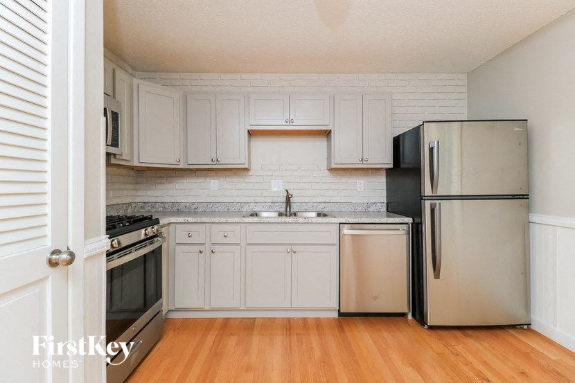 a kitchen with white cabinets and stainless steel appliances