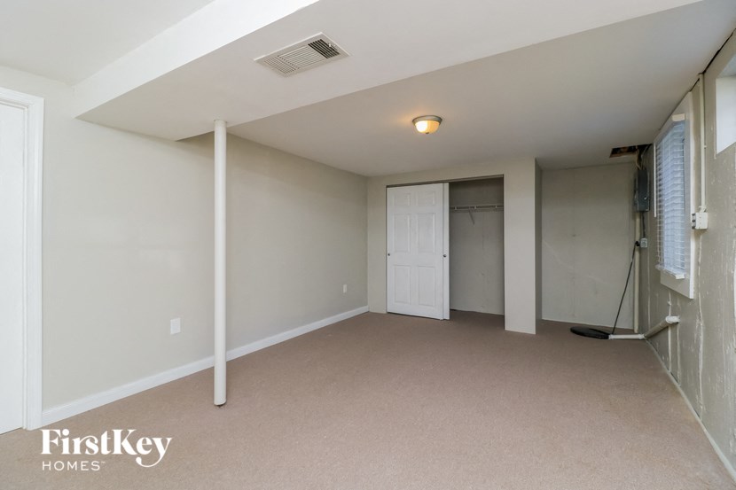 an empty living room with a door to a closet