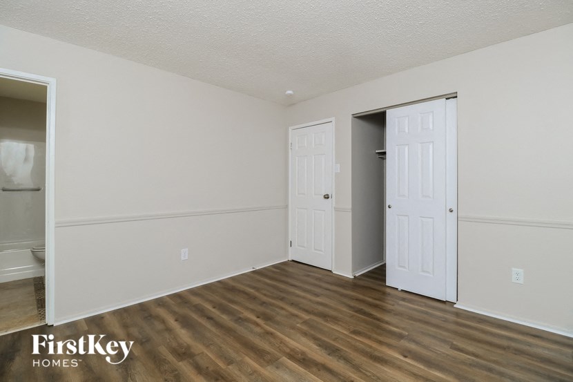the living room of a house with wood flooring and a closet