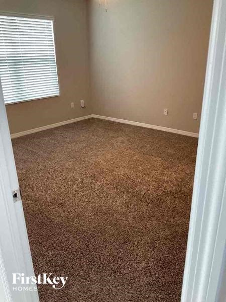 an empty room with a carpeted floor and a window