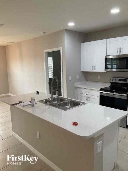 a kitchen with a white counter top and a sink