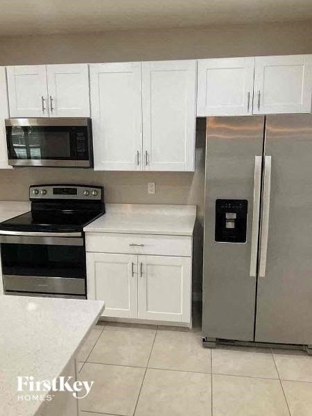 a kitchen with stainless steel appliances and white cabinets