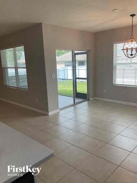 an empty living room with a tile floor and a sliding glass door