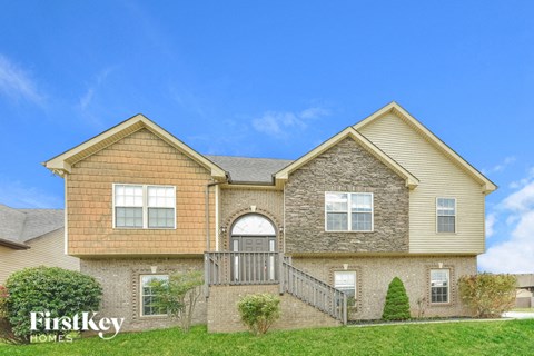 A two-story house with a stone facade and a large front porch.