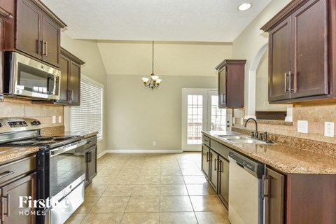 A kitchen with brown cabinets and a stainless steel oven.