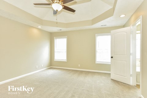 A spacious room with a ceiling fan and a door on the right side.