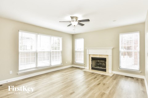 a living room with a fireplace and a ceiling fan