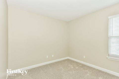 a bedroom with a carpeted floor and two windows