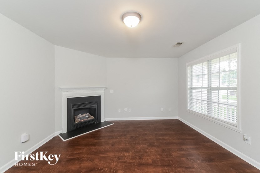 the living room with wood flooring and a fireplace