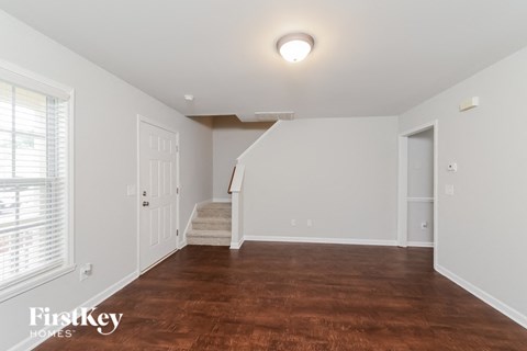 a renovated living room with a hardwood floor and white walls