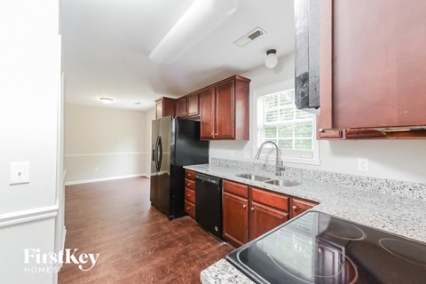 a kitchen with black appliances and granite counter tops and wooden cabinets